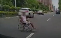 男子坐著輪椅在馬路上碰瓷擋在車前不讓離開